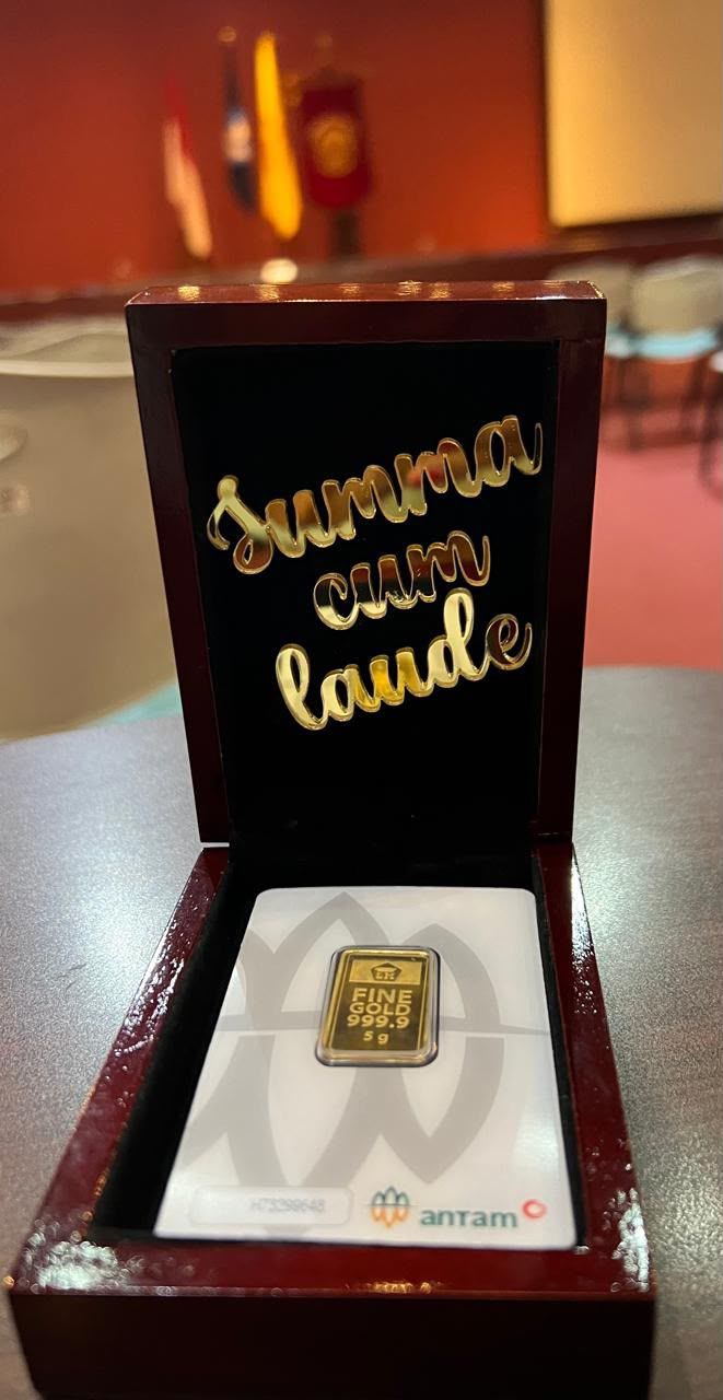 A gold keepsake engraved Summa Cum Laude