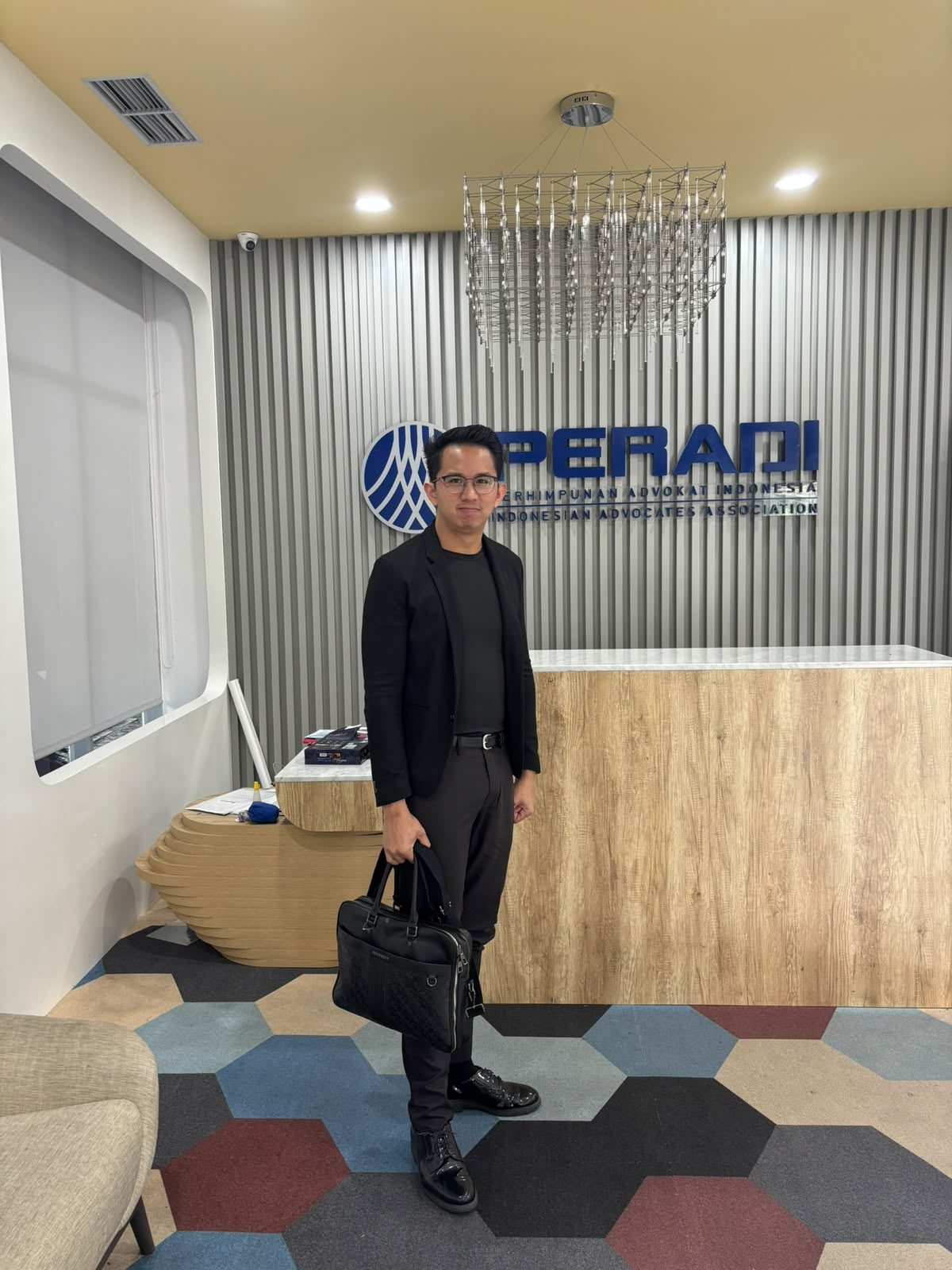 Dr. (Cand.) Putu George Matthew Simbolon, S.H., M.H. with his briefcase at the PERADI office