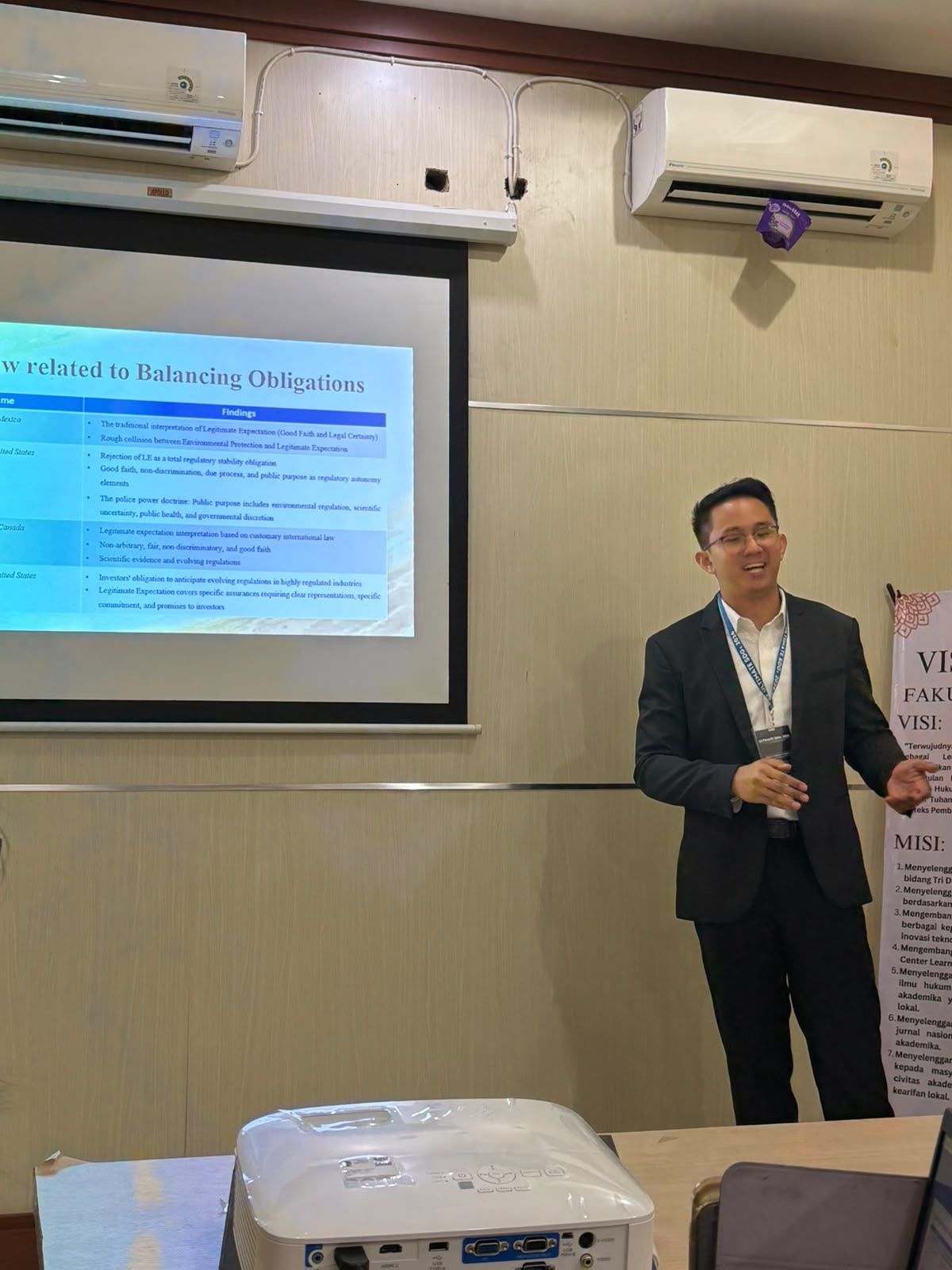 Dr. (Cand.) Putu George Matthew Simbolon, S.H., M.H. presenting research at an academic conference